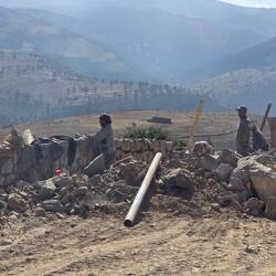 Brick layers building complex support walls for roads