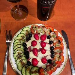 Mediteranes Gemüse auf Prosciutto di Parma bede.ckt von gehobeltem Parmesankäse im Goldrand