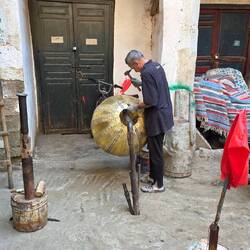 Artisan minutely honing a brass lamp