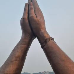 Praying hands statue at side of River Ganges