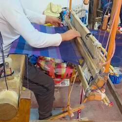 A weaver at his loomg.