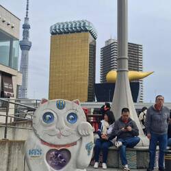 Treffpunkt zur Führung am Asakusa- Pier. Hinten die wg. Erdbeben liegendeFlamme -heute "golden poo"