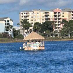 A raucous party pontoon bobs past in the bay