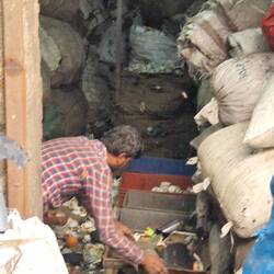Sorting the used plastic in a dark space. No mask or gloves