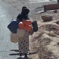 Women walk miles to place their water containers next to the road where a water truck fills them!