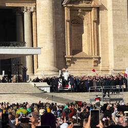 Durch die Menschenmenge hinauf auf's Podest wo alle möglichen ausgewählten Menschen saßen.