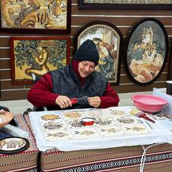 Das ist Zaynab. Sie sitzt im Rollstuhl, ist Mosaikkünstlerin und gerade dabei Steine zu brechen.