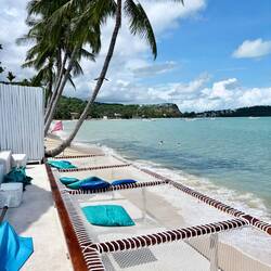 Der hintere Teil des Hotels mit Liegen und Netzen und Treppe direkt runter zum Meer