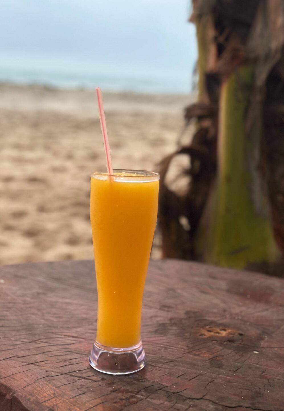 Frischer Mangosaft und die Füsse im Sand