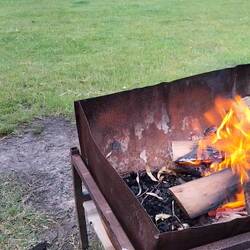 Met twee vesten/ jassen over elkaar buiten bij het vuurtje zitten
