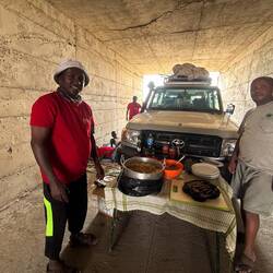 Die Crew hat einen schattigen Ort für die Mittagspause gefunden. Links der Koch.