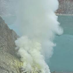 Thick plumes of toxic sulfur dioxide gas and smoke billow from within its crater.