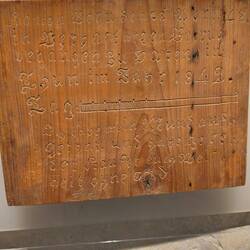 A piece of the wooden cells where prisoners carved during their stay.