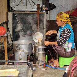 Straining the milk tea ( heated with milk, sugar and spices included.