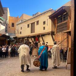 A trio of musicians in front of the artisan museum, they were swirling their pompoms on their heads