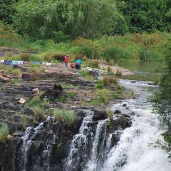 Über dem Fall ist ein illegales Dorf. Die Bewohner waschen oberhalb des Wasserfalls ihre Wäsche.