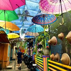 Everywhere creativity shines. Eclectic decorations hang, coloured umbrellas, balls, conical hats.