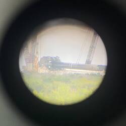 Die Falcon 9 wird aus dem Hangar Richtung Startrampe bewegt. (Durch Aussichtsfernglas fotografiert)