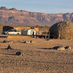 Living in a tent and straw hut with an old Mercedes at the front door