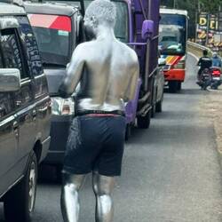A silver man requests donations at the traffic lights. Why? Who knows!