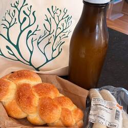 A calico bag, milk, bread and sausage