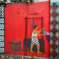 Street art showing a man boiling water ready to remove the wax from dyed fabric