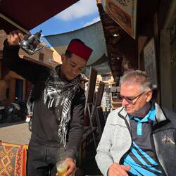 Hier wird Tee im hohen Strahl eingeschenkt