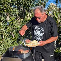 Die Patties werden auf einer Seite gebraten und auf die mit Käse bestreuen Buns gelegt