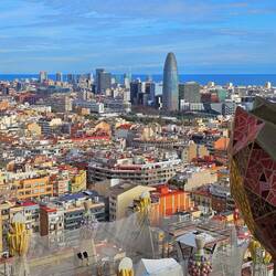 View from tower revealing stone sculptures on church, and Barcelona waterfront