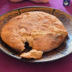 This bread is baked in amber's buried in the sand. When ready, the sand is brushed off. Delicious!