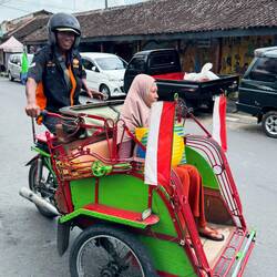 Grinning again after his grump, our becak driver is happy he now has a new customer.