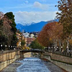 View walking along the river. Snowy mountains in background