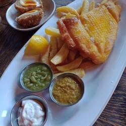 Lunch of fish, chips, mushy peas and curry sauce.