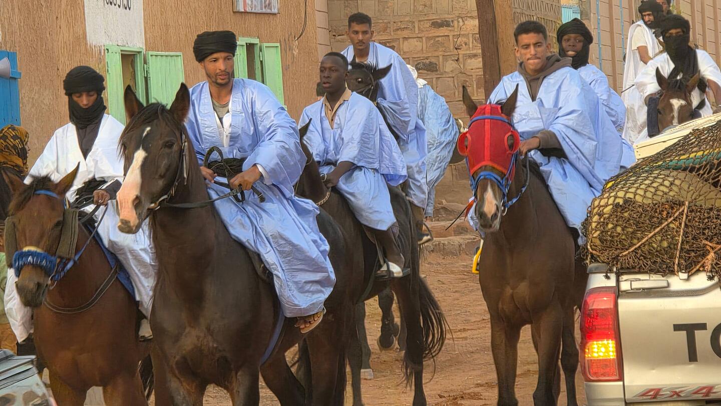 Traditional riders greet us as we enter the town.