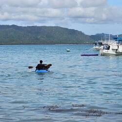 Rucksäcke werden per Kajak ins Boot gebracht.