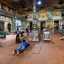 A Hindu man lies down in worship at the temple