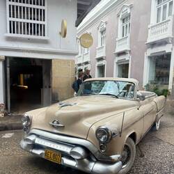 1950s-era car cruising the street—bright paint, chrome, and nostalgia.