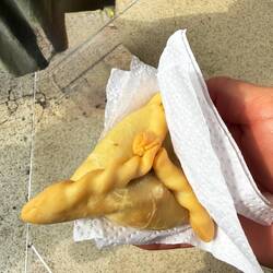 Hot, crisp empanada from the kiosk outside Éxito—cheap, fast, how locals eat on the run.