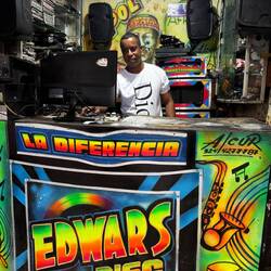A man mixing music in the market, providing sound for vendors and shoppers.