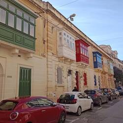 Enclosed balconies evolved under Knights of St. John for status, now a protected cultural symbol