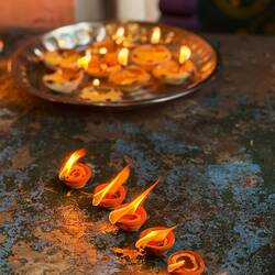 Dīyā oil lamp offerings signifying the triumph of light over darkness, devotion and surrender