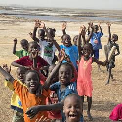 The next morning a hoard of children wave goodbye