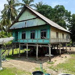 Adi's family home (they are sitting underneath). The tap is their running water
