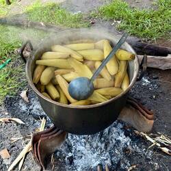 Salvaged roof tiles support the pot over an open fire