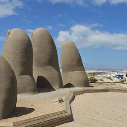The Fingers by Chilean artist Mario Irarrázabal, depicting five human fingers emerging from the sand