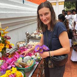 Klara legt ein paar Wasserlilien als Gabe an Buddha ab