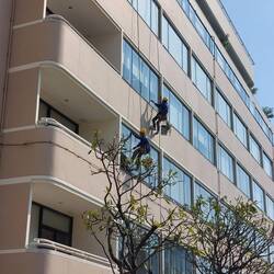 Blick vom Gartenvorbau im 6. Stock auf Fensterabdichtungsarbeiten an der Fassade