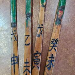 Am Holzstock befindet sich eine Nummer und Symbole.