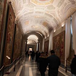 Hall filled with walls of tapestry maps