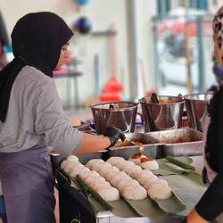 Produktion von Hühnchenreis im Bananablatt.